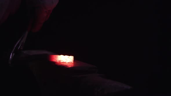 Red hot metal being hammered on anvil