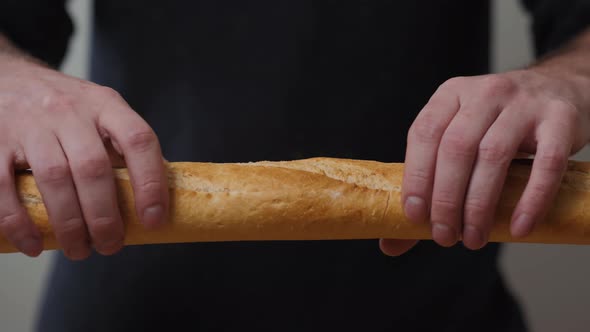 Closeup Organic Delicious Baguette Halves in the Hands of a Man on the Background