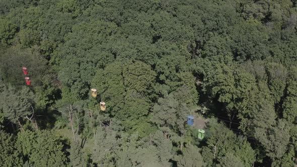 Aerial Drone Shot of a Cable Car Moving Over a Green Forest in Summer on a Synny Day. Kharkiv