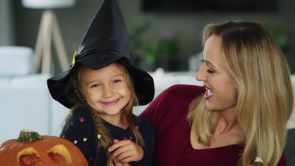 Happy mother and daughter with Halloween pumpkins