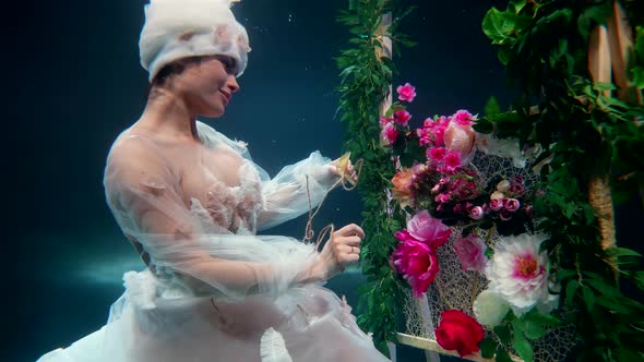 Subaquatic Slow Motion Shot with Beautiful Woman with Flowers Fabulous Fairy is Sewing Floral Carpet