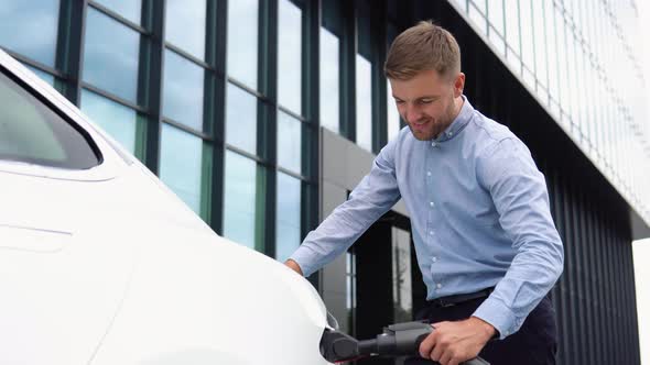 Bearded Man Cannot Plugging Power Supplier to Electric Car