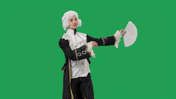 Portrait of Courtier Gentleman in Black Historical Vintage Suit and White Wig Waving a Fan and