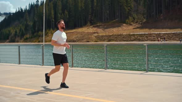 Young man running fast and intense in forest