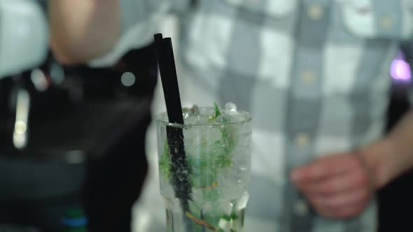 Process of preparing a Mojito cocktail with ice. Barman at work preparing cocktails.