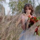 A Young Woman Dressed in a Gray Wedding Dress. She Has Flowers in Her Hand and Is in the Park - VideoHive Item for Sale