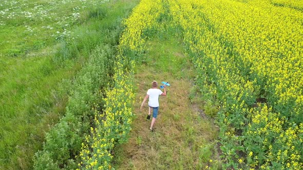 The Guy Runs Through the Flower Field Holding a Plane