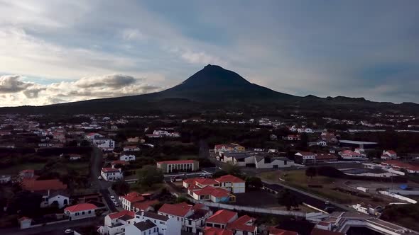 Aerial Sunrise shot over Madalena town flying towards Mount Pico in Pico Island, Azores. Portugal.