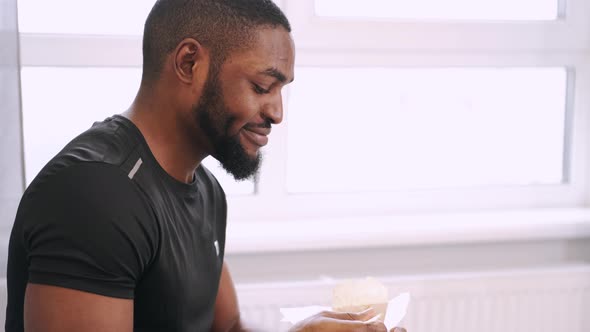 African American Man Eating Takeaway Noodles at Home