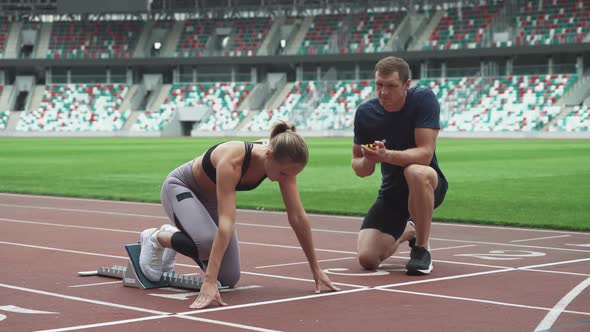 Female Sprinter are Training at the Stadium the Coach Controls the Time Training Run in