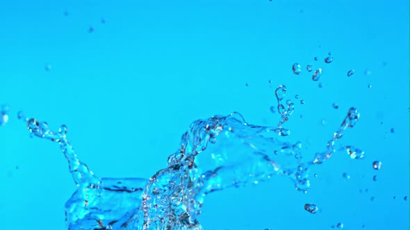 Super Slow Motion Splashes Water on a Blue Background