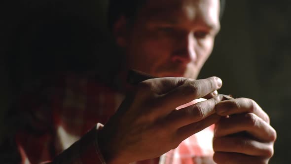 Portrait of Focused Wood Master Working in Handmade Studio Alone and Carving Patterns on Small