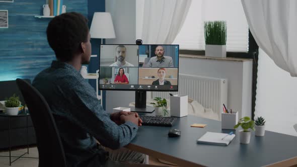 African American Man Waving to Colleagues Talking on Online Conference Internet Call