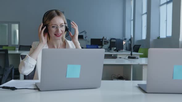 Smiled Young Lady Works with the Grey Laptop