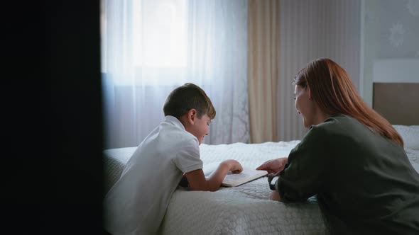 Mother Together with Male Child with Love in Heart To God Read Bible on Their Knees in Room, Faith alt