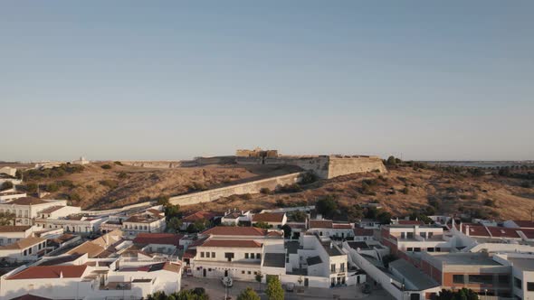 Fly over Castro Marin town towards the medieval Castle on hilltop. Algarve architecture, Portugal