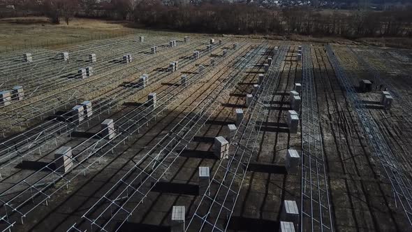 Aerial View of a Field Full of Racks for Solar Panels and Boxes Before Assembly