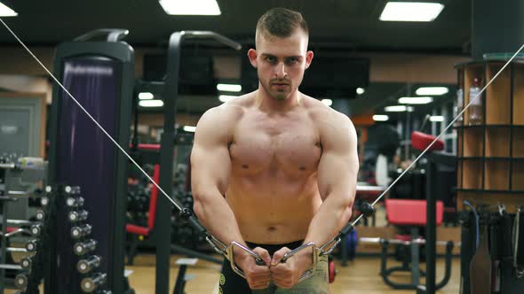 Closeup View of a Shirtless Handsome Athletic Man Doing Pectorals on the Crossover Trainer in the