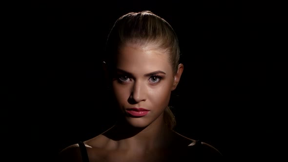 Face of a Beautiful Girl with Blue Eye Makeup and Pink Lips. Black. Closeup