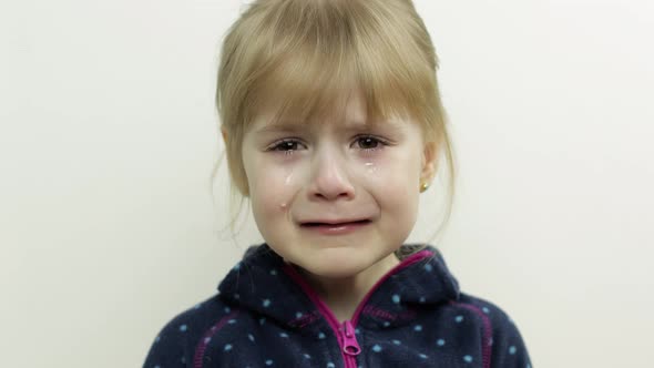 Portrait of Little Child Girl Crying with Tears Down Her Face. White Background