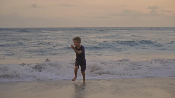 Happy Boy Running from Waves at Beach