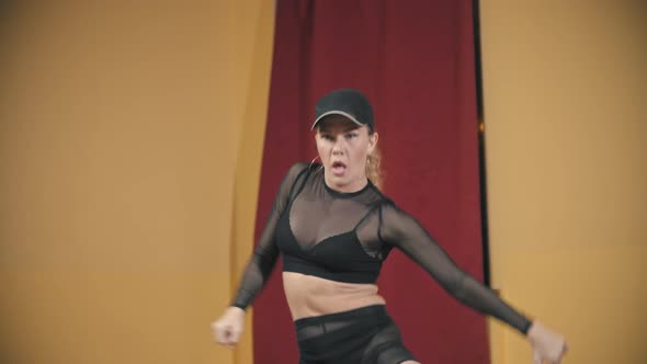Blonde Woman in Black Translucent Suit Dancing in the Yellow Studio