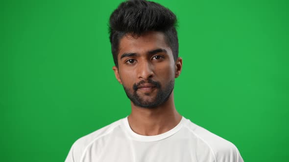 Handsome Bearded Middle Eastern Young Man with Brown Eyes Looking at Camera Showing Football Ball at