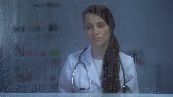 Female Doctor With Stethoscope Depressed After Patients Death, Rainy Weather