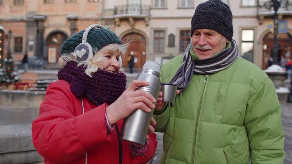 Senior Wife Husband Tourists Drinking From Thermos Enjoying Hot Drink Tea on City Central Street