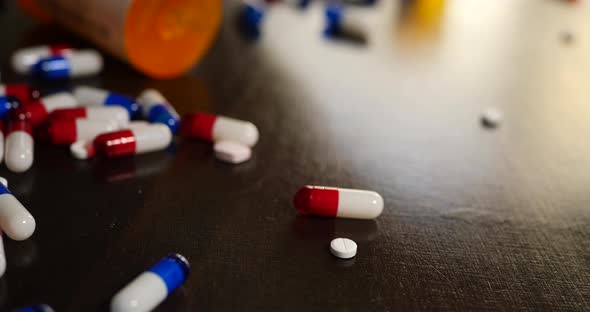 A drug addict pouring out prescription painkiller pills, narcotics and medicine in a frantic search