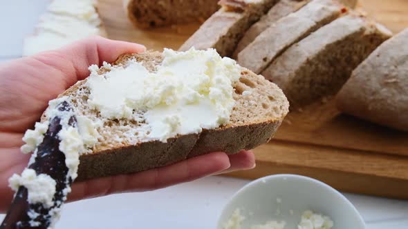 Spreading curd cheese on a piece of bread. 