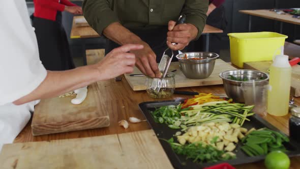 Caucasian female chef teaching diverse group