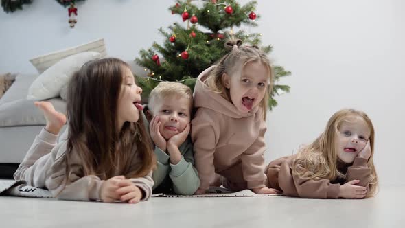 Playful Children Lay Near the Christmas Tree