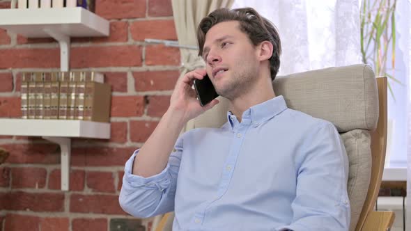 Young Man Talking on Smartphone in Office 