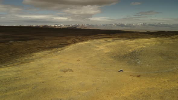 The Car Travels Through the Deserted Mountain Steppe