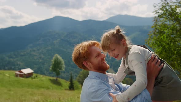 Father Picking Up Daughter on Mountain Valley Close Up