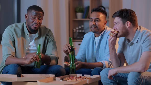 Happy Male Friends with Beer Eating Pizza at Home