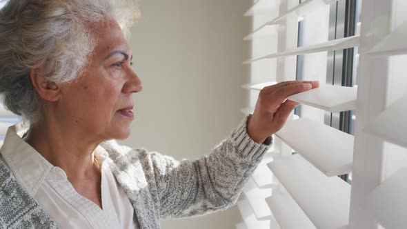 African american senior woman looking out of the window at home