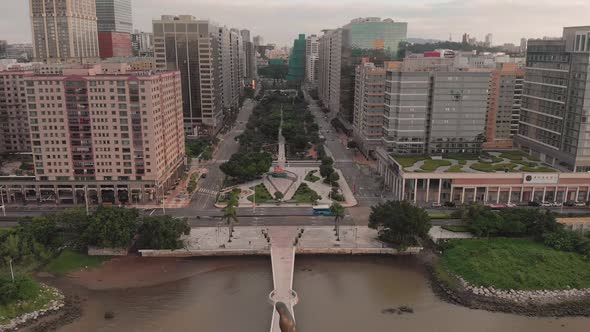 Falling aerial shot behind Kun Iam golden statue in NAPE business area in Macau