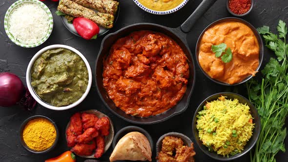 Various Indian Dishes on a Table. Spicy Chicken Tikka Masala in Iron Pan