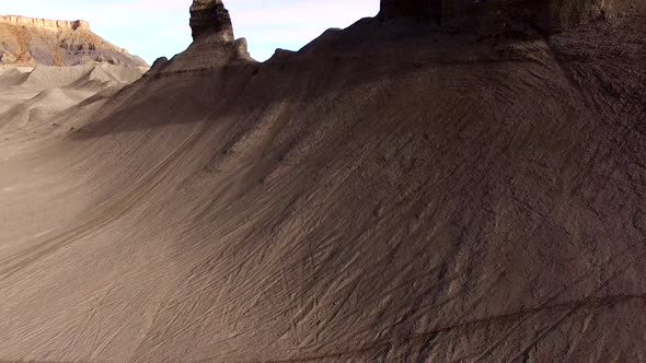 Flying over sandy hill revealing desert landscape covered in tire tracks