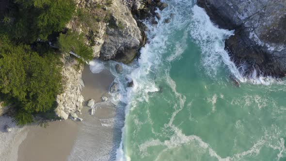 Top Down Forward Pan of McWay Falls and Waves Crashing on the Coast of Big Sur