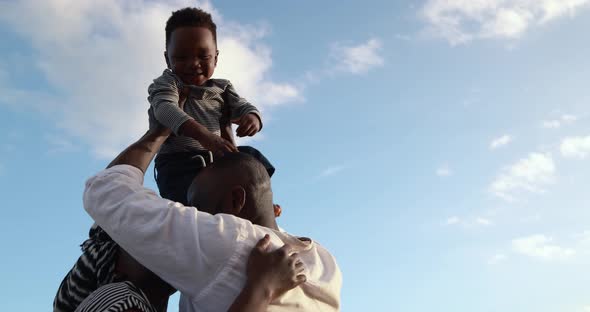 African parents and cute little son having fun on the beach at sunset