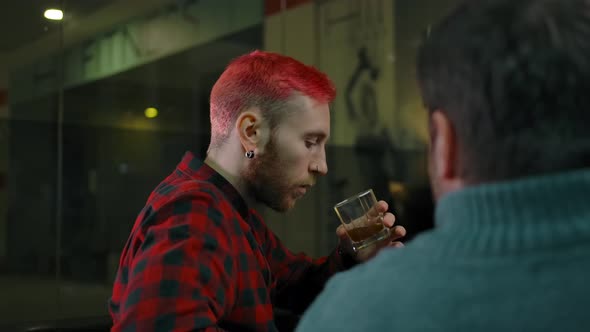 Bearded Guy Drinking Alcohol and Speaking with Friend in Barbershop