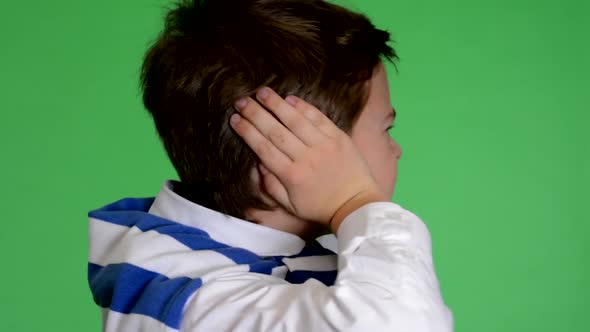 Young Handsome Child Boy Covers His Ears (Noise) - Green Screen - Closeup - Studio