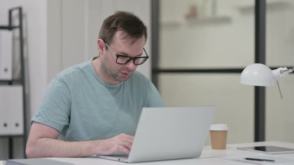 Young Man Taking Nap While Working on Laptop