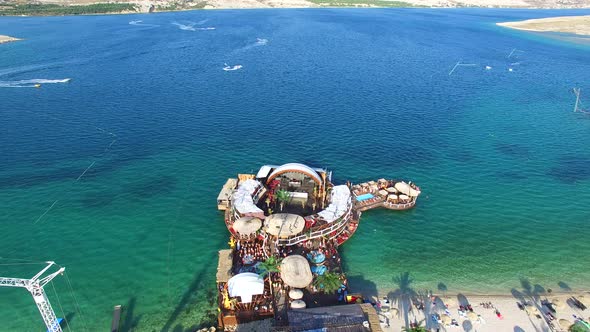 Aerial view of people partying in club on the sea water, Pag island