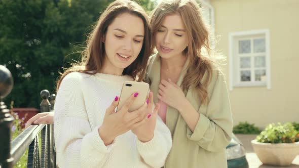 Two young beautiful women posing outdoors 