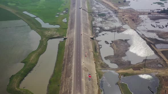 Aerial view of a road among the fields in Sapahar, Rajshahi, Bangladesh.