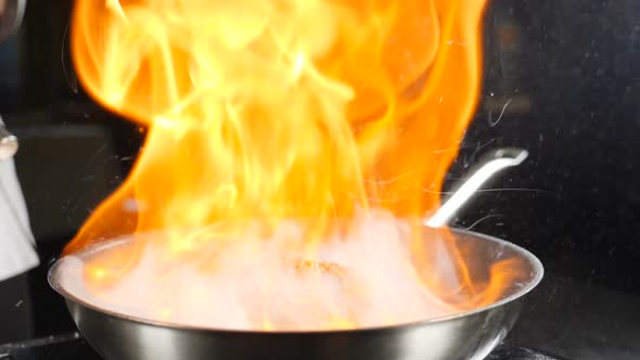 Chef Making Steak Fillet Mignon in Flambe Style on a Grill Pan. Cooking in Restaurant in Slow Motion